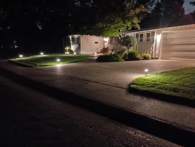 Front yard path and driveway lit by low-voltage landscape lighting at night